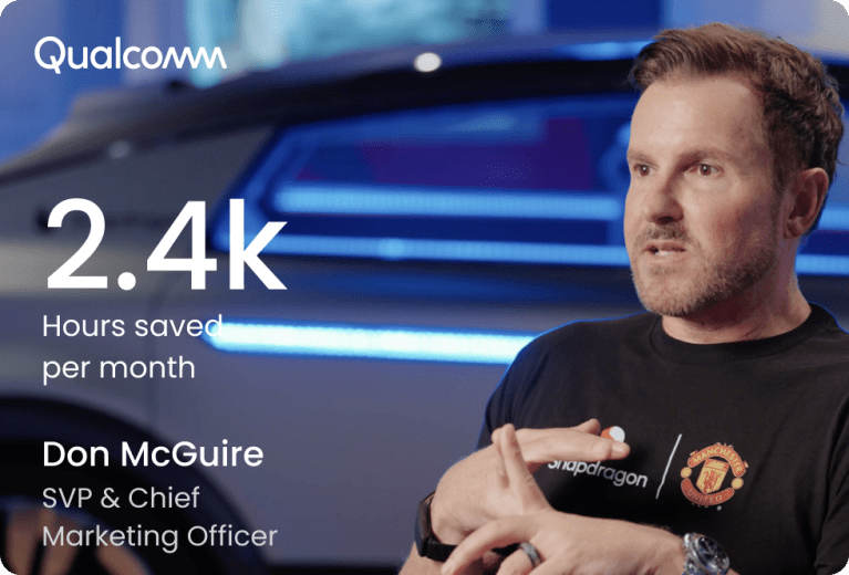 Man with reddish-brown beard wearing a black t-shirt with "Snapdragon" logo and Manchester United emblem, sitting in a relaxed pose with blurred blue-toned technology screens in the background. The Qualcomm logo appears in white at the top left. Large white text displays "2.4k" with "Hours saved per month" below it. At the bottom left, white text reads "Don McGuire", "SVP & Chief", and "Marketing Officer".